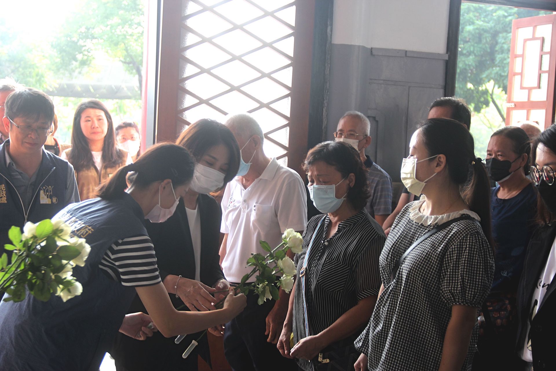 周春米縣長向家屬獻上白玫瑰致意。